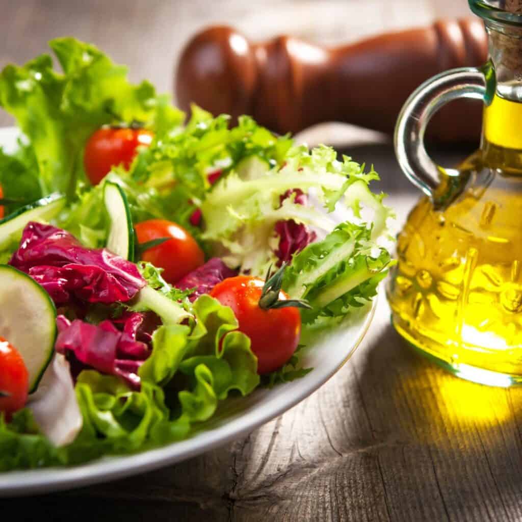 salad with tomatoes and cucumbers next to a bottle of olive oil